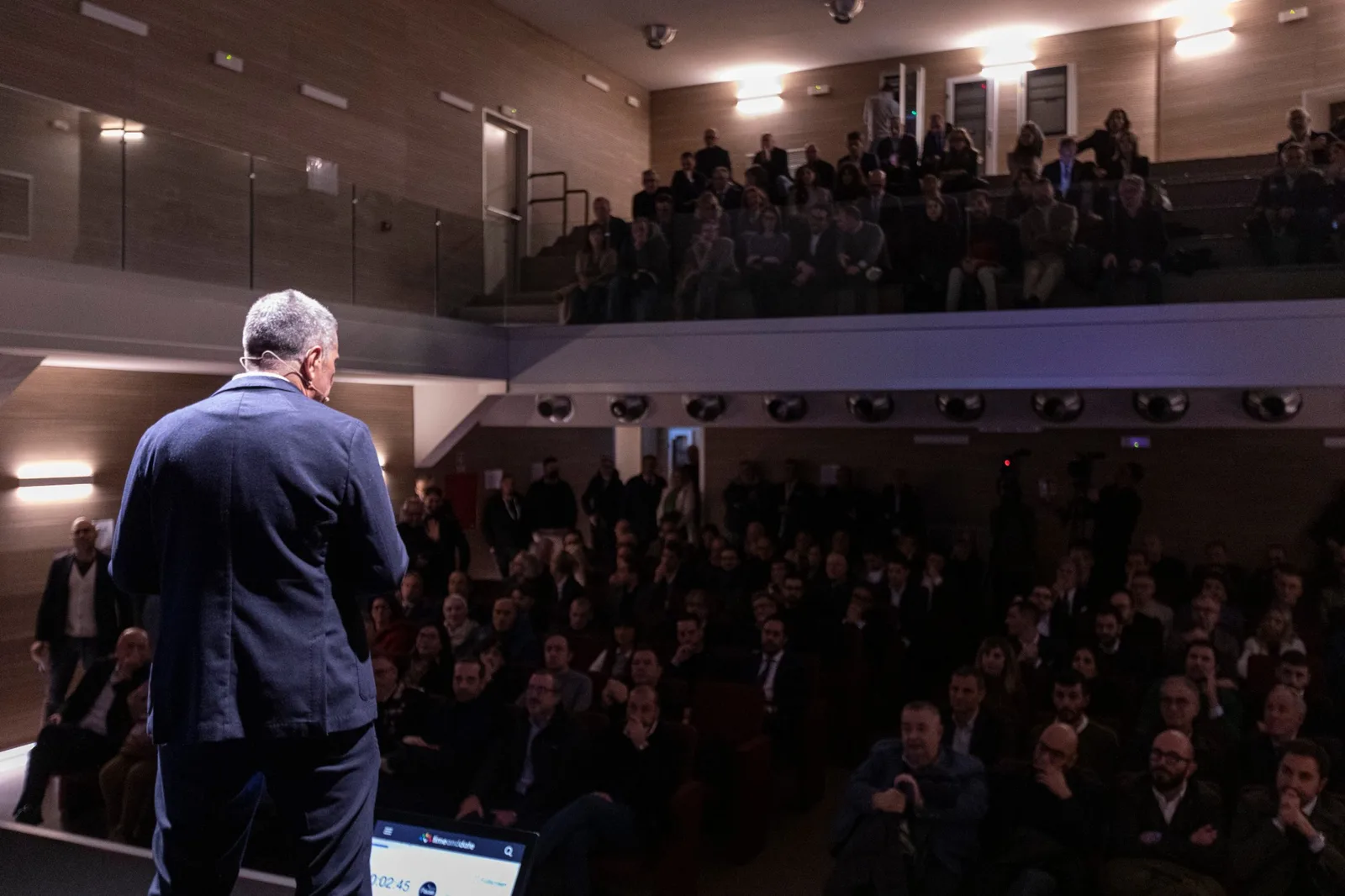 Giancarlo De Leonardo di spalle sul palco del Teatro Vittoria, di fronte alla platea gremita del keynote inaugurale Innovation Bridge